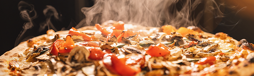 Hot steaming pizza topped with tomato and onions